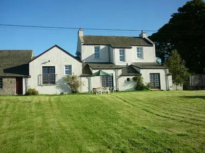 a large white house with a large yard at Midkinleith Farm Holiday Cottage in Edinburgh
