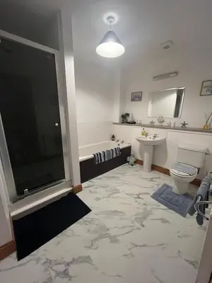 a bathroom with a tub and a toilet and a sink at Midkinleith Farm Holiday Cottage in Edinburgh