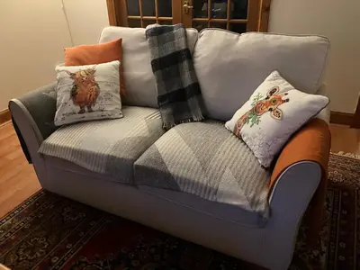 a couch with pillows on it in a living room at Midkinleith Farm Holiday Cottage in Edinburgh