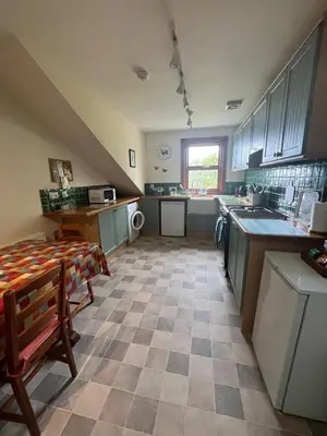 a large kitchen with a sink and a table at Midkinleith Farm Holiday Cottage in Edinburgh
