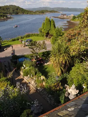 a garden with a view of a body of water at The Moorings in Tarbert
