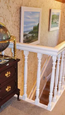 a staircase with white railings and a painting on the wall at The Moorings in Tarbert
