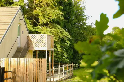 a wooden fence next to a small building at Badgers Den in Linlithgow