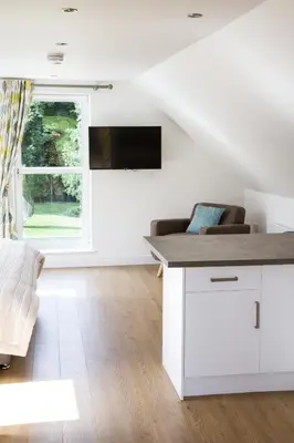 a white living room with a couch and a window at Badgers Den in Linlithgow