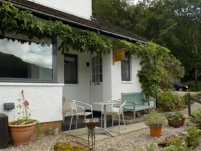 a patio with a table and chairs in front of a house at 16 Admiralty in Arrochar