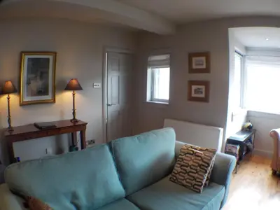 a living room with a blue couch and a window at 16 Admiralty in Arrochar