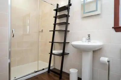 a bathroom with a ladder next to a sink and a shower at Rowan Cottage in Blairmore