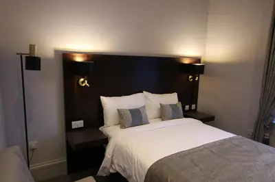 a bedroom with a large bed with a black headboard at Castlecary House Hotel in Cumbernauld