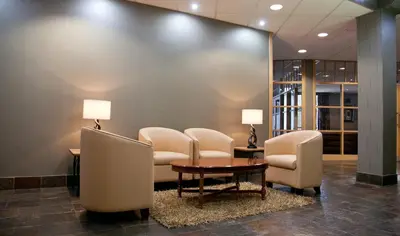 a waiting room with chairs and a table and a table and chairs at Castlecary House Hotel in Cumbernauld