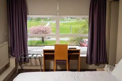 a table and chair in front of a window at The Titan By Greene King Inns in Clydebank