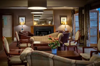 a living room with couches and a table and a fireplace at Buchanan Arms Hotel & Leisure, Sure Hotel Collection in Drymen