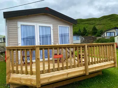 a small house with a large wooden deck at Bellochantuy Beach in Bellochantuy
