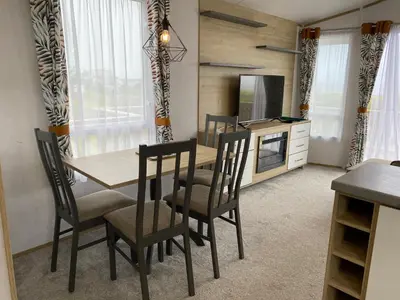 a dining room with a table and chairs and a television at Bellochantuy Beach in Bellochantuy