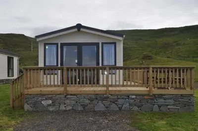 a small house with a large wooden deck at Bellochantuy Beach in Bellochantuy