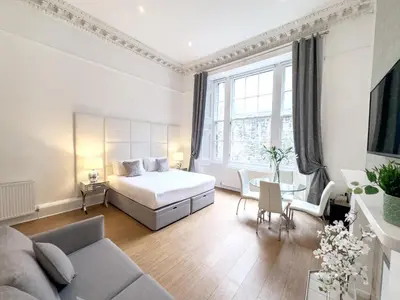 a bedroom with a bed and a living room at Hanover 71 Suites in Edinburgh