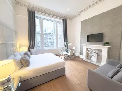 a bedroom with a bed and a living room with a fireplace at Hanover 71 Suites in Edinburgh