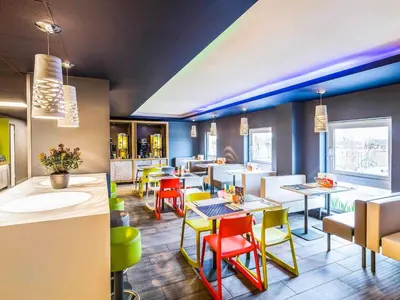 a restaurant with colorful chairs and tables in a room at ibis budget Glasgow in Glasgow