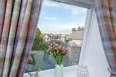 a window with a vase of flowers on a window sill at 6 Beech Court in Dunblane