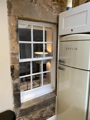 a kitchen with a window next to a refrigerator at Sea Hollies in Aberdour