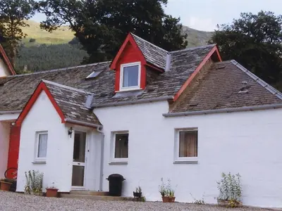 a white house with a red roof at Inverardran House in Crianlarich