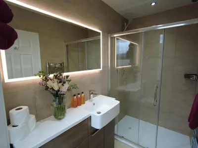 a bathroom with a sink and a glass shower at Inverardran House in Crianlarich