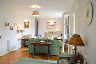 a living room with a couch and a table at Teal Cottage in Clachan of Glendaruel