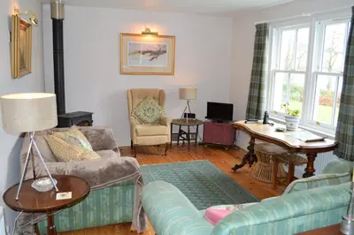 a living room with a couch and a table at Teal Cottage in Clachan of Glendaruel