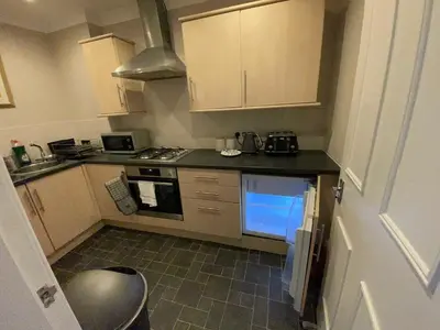 a small kitchen with a stove and a sink at Apartment 2 Bed West End in Glasgow