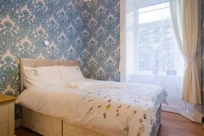 a small bedroom with a bed with a window at Watson Crescent in Edinburgh