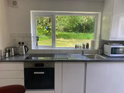 a kitchen with a sink and a window at Woodland Cabins, Glencoe in Ballachulish