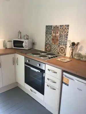 a kitchen with a stove and a microwave at Woodland Cabins, Glencoe in Ballachulish