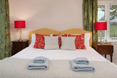 a bedroom with a bed with towels on it at East Lodge in Crieff