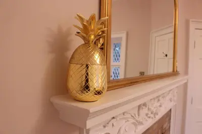 a gold vase sitting on a mantle in front of a mirror at East Lodge in Crieff