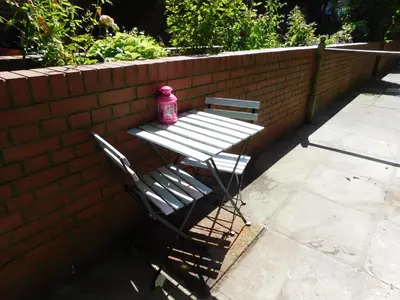 a bench with a pink bottle on it next to a brick wall at Fountainbridge Flat in Edinburgh