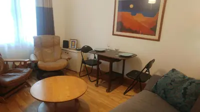 a living room with a couch and a table and chairs at Fountainbridge Flat in Edinburgh