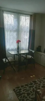 a table with a vase of flowers on it in front of a window at Fountainbridge Flat in Edinburgh