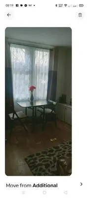 a table with a vase on it in a room with a window at Fountainbridge Flat in Edinburgh