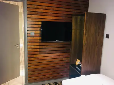 a room with a wooden wall with a flat screen tv at The Commercial Hotel in Wishaw