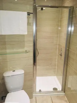 a bathroom with a shower and a toilet at The Commercial Hotel in Wishaw