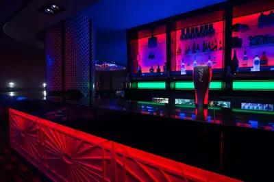 a bar with red and green lights in a room at The Commercial Hotel in Wishaw