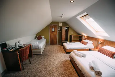 a hotel room with two beds and a desk at The Commercial Hotel in Wishaw