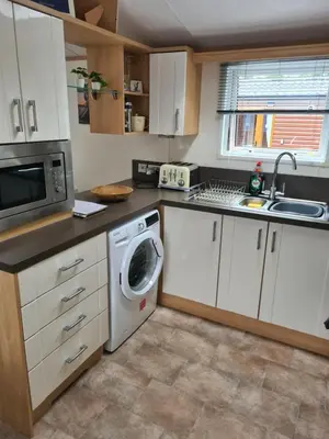 a kitchen with a washing machine and a sink at Bear Lodge in Auchterarder