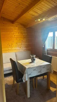 a table and chairs in a room with a couch at Lochinvar - Highland Log Cabin with Private Hot Tub in Airdrie