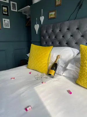 a bed with a bottle of champagne on it at Albyn Townhouse in Edinburgh