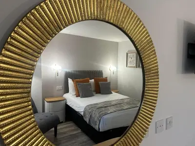 a bedroom with a bed and a large mirror at The Tontine Hotel in Greenock