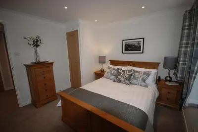 a bedroom with a large bed and two night stands at The Beeches at Gleneagles in Auchterarder