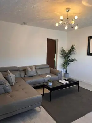 a living room with a couch and a coffee table at Kelpies Serviced Apartments- Russell in Falkirk