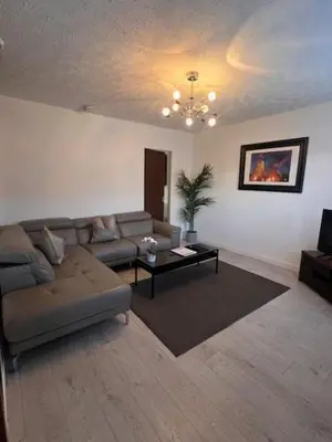 a living room with a couch and a table at Kelpies Serviced Apartments- Russell in Falkirk