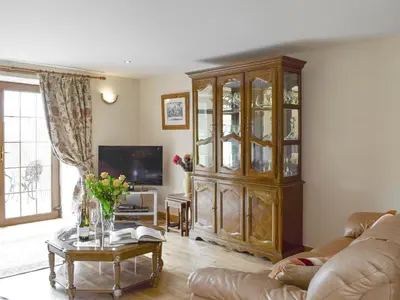 a living room with a large wooden cabinet and a table at The Stables - Uk5532 in Kepculloch