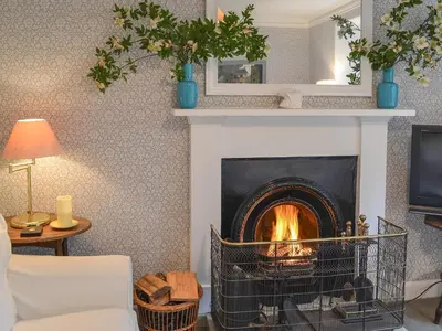 a fireplace in a living room with a fire place at Garden Cottage in Strachur